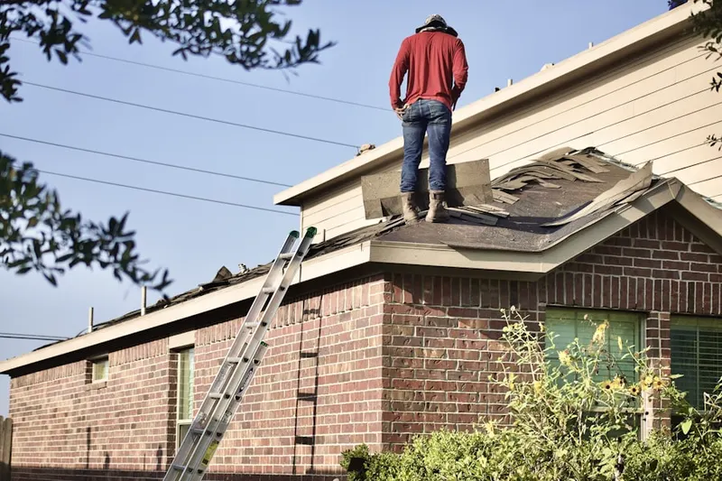 Professional roofer working on a residential roof in Sumpter